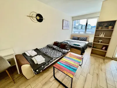 a bedroom with a bed and a couch and a table at Joyful Studio in Sofia