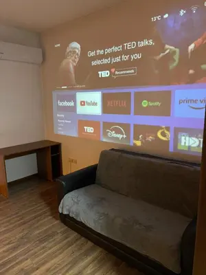 a room with a couch in front of a large screen at Cinema house at Sofia center in Sofia