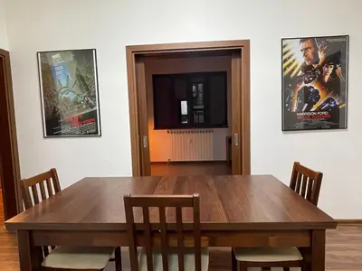 a dining room table with chairs and posters on the wall at Cinema house at Sofia center in Sofia