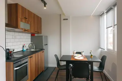 a small kitchen with a table and chairs in a room at Serdica Tower View DT Parking Wi-Fi AC in Sofia