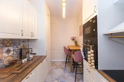 a kitchen with white cabinets and a table and a stove at The Pearl Downtown in Sofia