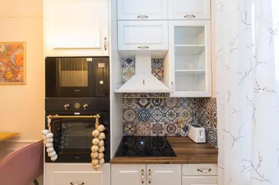 a kitchen with white cabinets and a black oven at The Pearl Downtown in Sofia