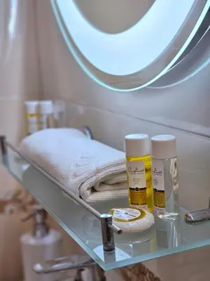 a shelf with two bottles of moisturizers and a mirror at Two Big Bed Apartment & FREE Underground Parking in Sofia