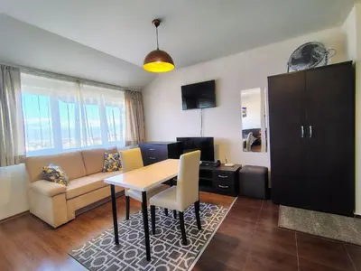 a living room with a couch and a table at Bansko Tower Cozy Studio with Mountain View in Bansko