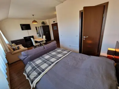 a bedroom with a bed and a living room at Bansko Tower Cozy Studio with Mountain View in Bansko