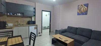 a living room with a couch and a table and a kitchen at Апартаменти Борови хълмове in Pamporovo