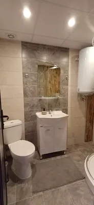 a bathroom with a white toilet and a sink at Апартаменти Борови хълмове in Pamporovo