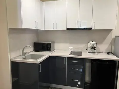 a kitchen with white cabinets and a sink and a microwave at Sahat Tepe Studio in Plovdiv