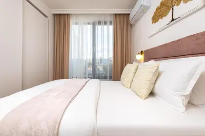 a bedroom with a large white bed with a window at Stylish City Escape 1BD Apartment in Plovdiv in Plovdiv