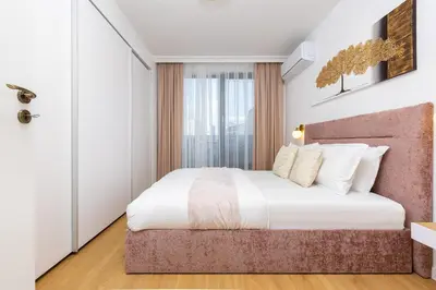 a bedroom with a large bed with white sheets at Stylish City Escape 1BD Apartment in Plovdiv in Plovdiv