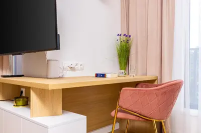 a room with a desk with a television and a chair at Stylish City Escape 1BD Apartment in Plovdiv in Plovdiv