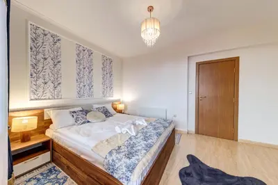 a bedroom with a bed and a chandelier at Ski Slope Getaway at Grand Monastery in Pamporovo