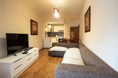 a living room with a couch and a flat screen tv at Cozy and warm apartment with a separate bedroom in Bansko