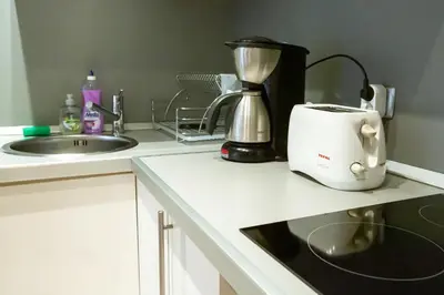 a kitchen counter with a blender and a sink at Cozy and warm apartment with a separate bedroom in Bansko