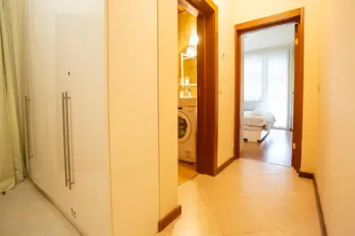 a hallway with a door open to a laundry room at Cozy and warm apartment with a separate bedroom in Bansko