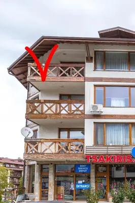 a building with a red arrow on top of it at Cozy and warm apartment with a separate bedroom in Bansko