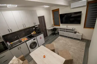 a kitchen with a table and a sink and a stove at Апартамент Милена in Smolyan