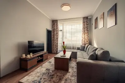 a living room with a couch and a television at Rila Zen Apartment in Samokov