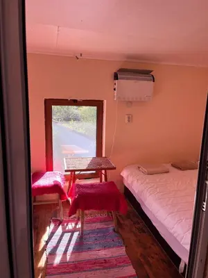 a room with a bed and a table and a window at Country House БатЖоро