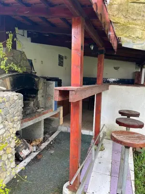 a table and two stools in front of a fireplace at Country House БатЖоро