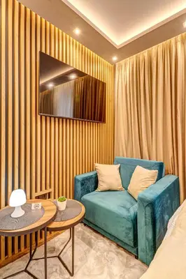 a living room with a blue couch and a table at Grand Resort Pamporovo Apartments in Pamporovo