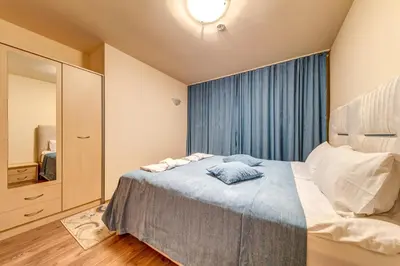 a small bedroom with a bed and a mirror at Grand Resort Pamporovo Apartments in Pamporovo