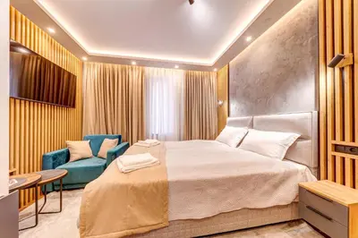 a bedroom with a bed and a blue chair at Grand Resort Pamporovo Apartments in Pamporovo