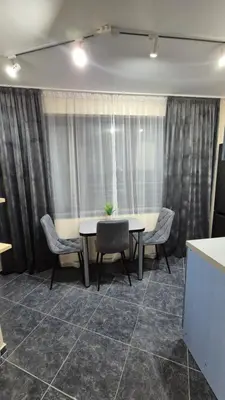 a table and chairs in a room with curtains at Elit Apartment - City and Hill view in Plovdiv