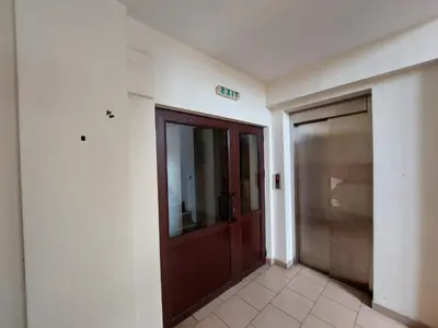 an empty hallway with a wooden door in a building at Elit Apartment - City and Hill view in Plovdiv