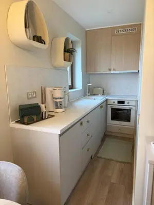 a kitchen with white cabinets and a counter top at Appartement moderne et chic Ski & Spa Bansko in Bansko