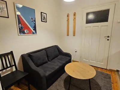 a living room with a black couch and a table at Super Central 2BR FREE Parking in Sofia
