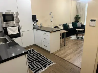 a kitchen and living room with a refrigerator and a table at Guest House Amaya Med 2 in Plovdiv