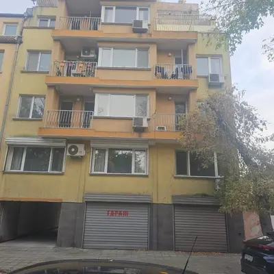a tall yellow building with a lot of windows at Luxury Suite Old Plovdiv with parking in Plovdiv