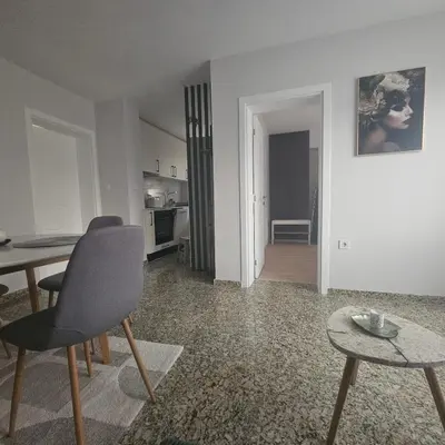 a living room with a table and chairs and a kitchen at Luxury Suite Old Plovdiv with parking in Plovdiv