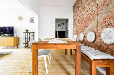a dining room with a wooden table and a brick wall at Boho Gem in Sofia