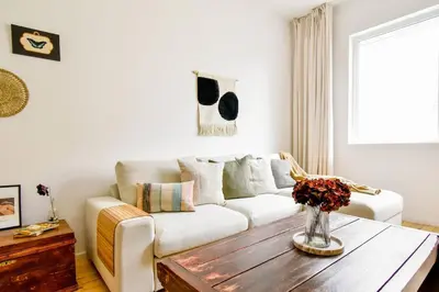 a living room with a white couch and a wooden table at Boho Gem in Sofia