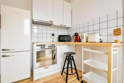 a kitchen with white cabinets and a wooden counter top at Boho Gem in Sofia