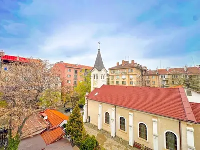a large white church with a steeple in a city at Boho Gem in Sofia