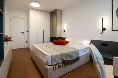 a bedroom with a bed with a red pillow on it at Alta Vita - Brand New - Luxury - Parking - Wash&Dry - Gas Heating in Sofia