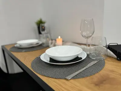 a wooden table with a plate and wine glasses on it at Le bijou-Беломорски in Plovdiv