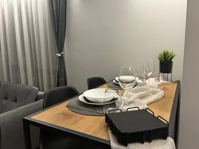 a dining room table with wine glasses and a black bag at Le bijou-Беломорски in Plovdiv