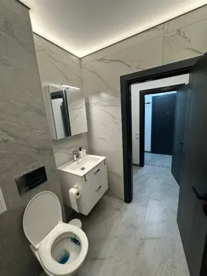 a bathroom with a white toilet and a sink at Le bijou-Беломорски in Plovdiv