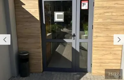 a glass door to a building with two arrows pointing toward it at Le bijou-Tomov Plaza in Plovdiv