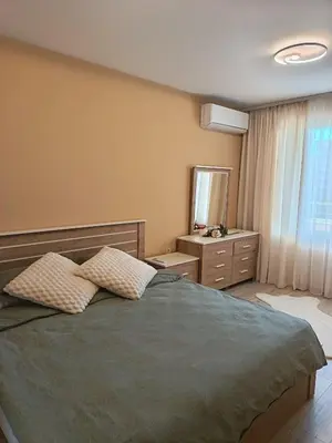 a bedroom with a bed and a dresser and a window at Boutique apartment family 5 in Plovdiv