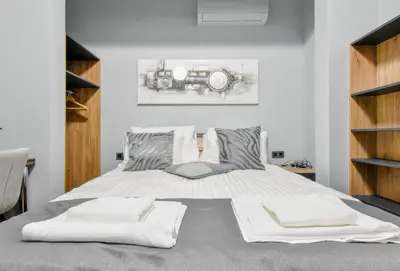 a bedroom with a large bed with white sheets at Stylish 2-Bedroom Sofia Stay in Sofia