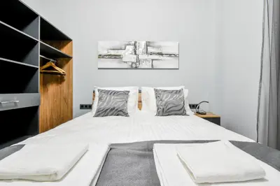 a bedroom with a large bed with white sheets at Stylish 2-Bedroom Sofia Stay in Sofia