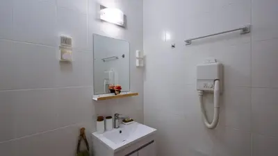 a white bathroom with a sink and a mirror at Студио Young Gogh in Pamporovo