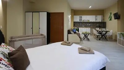 a bedroom with a large white bed with shoes on it at Студио Young Gogh in Pamporovo