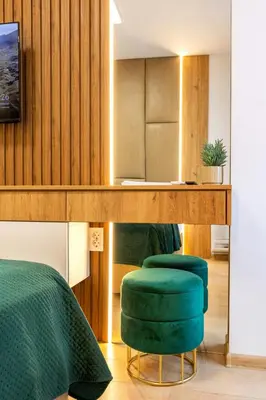 a bedroom with two green chairs and a table at Evergreen 301 - Luxury ski apartment near gondola in Bansko