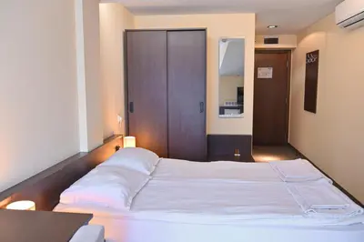a large white bed in a room with a wooden door at Хотел Елица in Bansko